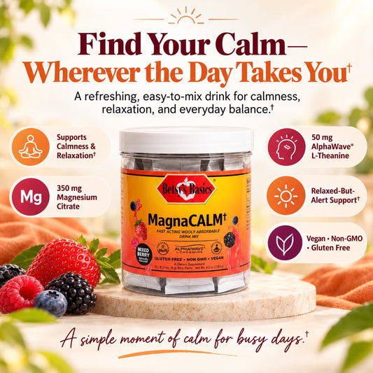 A jar of Hey! Basics MagnaCALM liquid supplement centered on a light wood surface, surrounded by fresh berries and orange fabric, with marketing text and icons about magnesium, alpha-wave support, and vegan/non-GMO qualities.