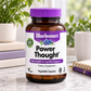 A bottle of Bluebonnet Power Thought dietary supplement, featuring an amber glass bottle with a purple cap and a white label with purple and green accents, set on a marble surface with a blurred background of plants and office items.