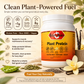 A jar of Betsi's Basics Plant Protein powder shown on a styled background with vanilla flowers, pea pods, and text callouts about clean plant-powered fuel. The product is a white plastic tub with a large orange label and white cap, set against a warm beige background with additional ingredient imagery.
