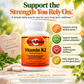 Betsy's Basics Vitamin K2 dietary supplement bottle on a bright, sunny outdoor-style background with green leaves and beige stones. The bottle is white with an orange label.