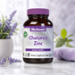 A bottle of Bluebonnet Chelated Zinc dietary supplement, featuring an amber glass bottle and a purple cap, set on a marble surface with lavender flowers and a soft-focus background.