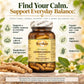 A jar of Bely's Basics Ashwagandha herbal supplement centered on a styled background with herbs, leaves, and text callouts about its benefits. The product is shown in an amber glass jar with a white and brown label and a sealed lid, surrounded by natural props and green leaf icons.
