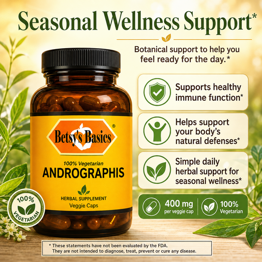 Betsy's Basics Andrographis Seasonal Wellness Support herbal supplement bottle with a black cap and yellow label, shown with green leaves and text callouts on a warm beige background.